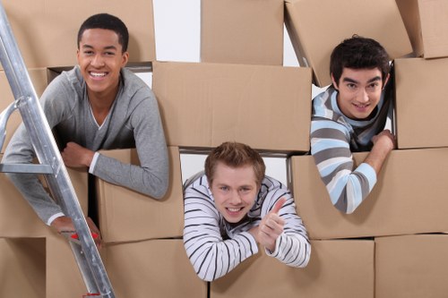 Movers carrying furniture through a stairwell in a Bromley flat